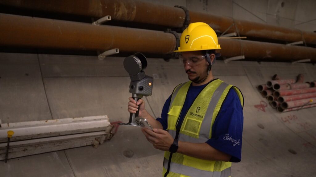 Surveyor holding the FJD Trion T1 and checking the scan on a phone inside a tunnel